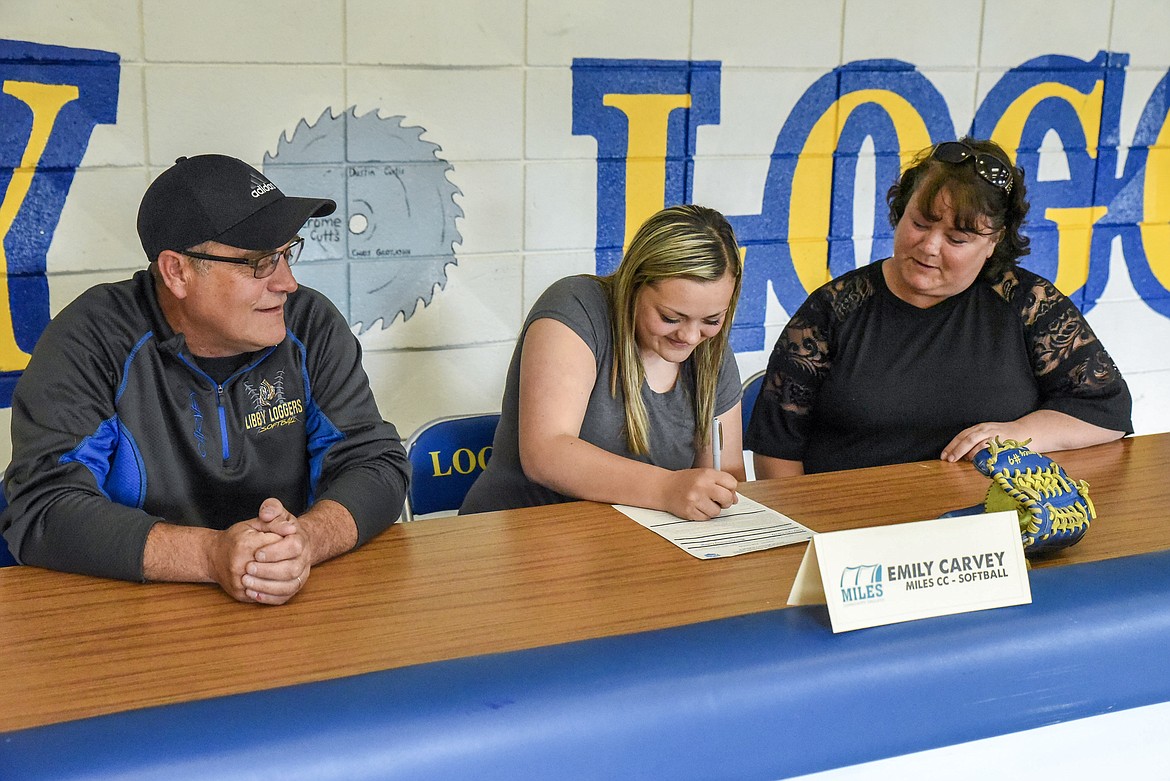 Libby High School softball senior infielder Emily Carvey signs to play softball at Miles Community College on Wednesday. Pictured are her father, Floyd Carvey, Emily and her mother, Charie Carvey. (Ben Kibbey/The Western News)