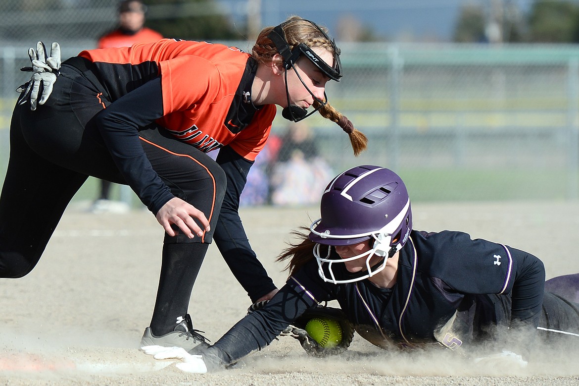 Flathead first baseman Maddie Engle applies the tag to Polson's Kobbey Smith as she dives back into first base after a snap throw from Bravettes catcher Sydney Olson in the second inning at Kidsports Complex on Thursday. Smith was safe on the play. (Casey Kreider/Daily Inter Lake)