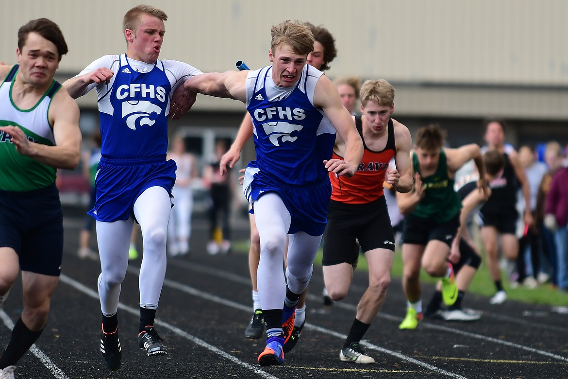 Danny Henjum, left, makes the exchange with Zack Pletcher during the 4X100 relay at the ARM Meet in Whitefish Saturday. (Jeremy Weber photo)