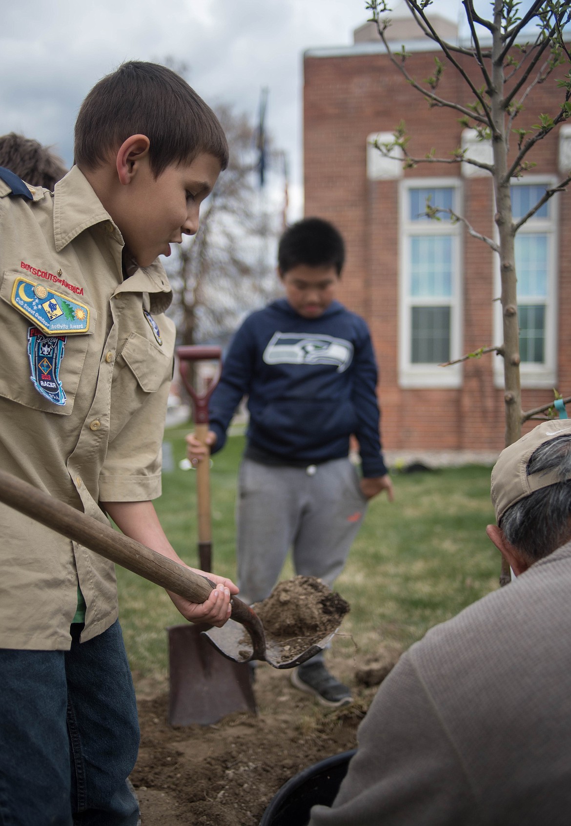 Ignacio Guerra, left, and Matt Shao shovel dirt into a newly planted tree during a planting ceremony with the Libby Tree Board for Arbor Day, April 26 in Libby.