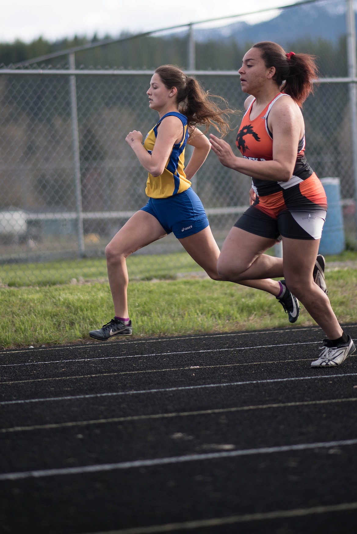 Emma Gruber, left, races the 200 meter, Tuesday at the Lincoln County Track Meet in Libby. (Luke Hollister/The Western News)