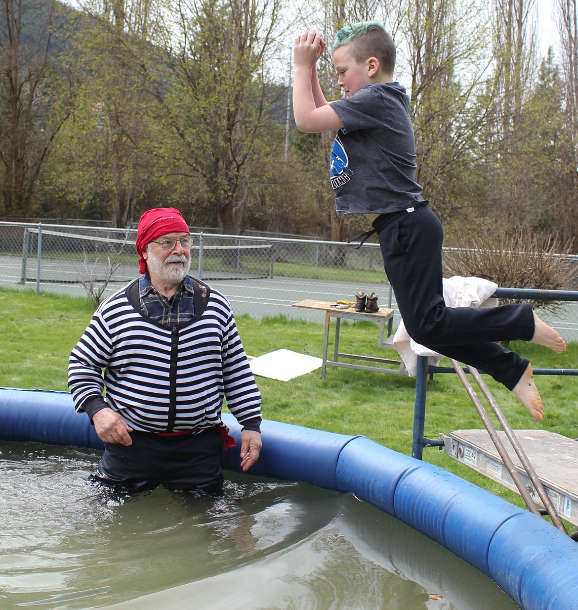 COMMITTEE MEMBER Tom McCloskey watches 8-year-old Cael Crabb jump into the freezing water at the Walk the Plank fundraiser on Sunday, April 28. Fun was had by all, and $4,800 was raised for the Superior pool project.
