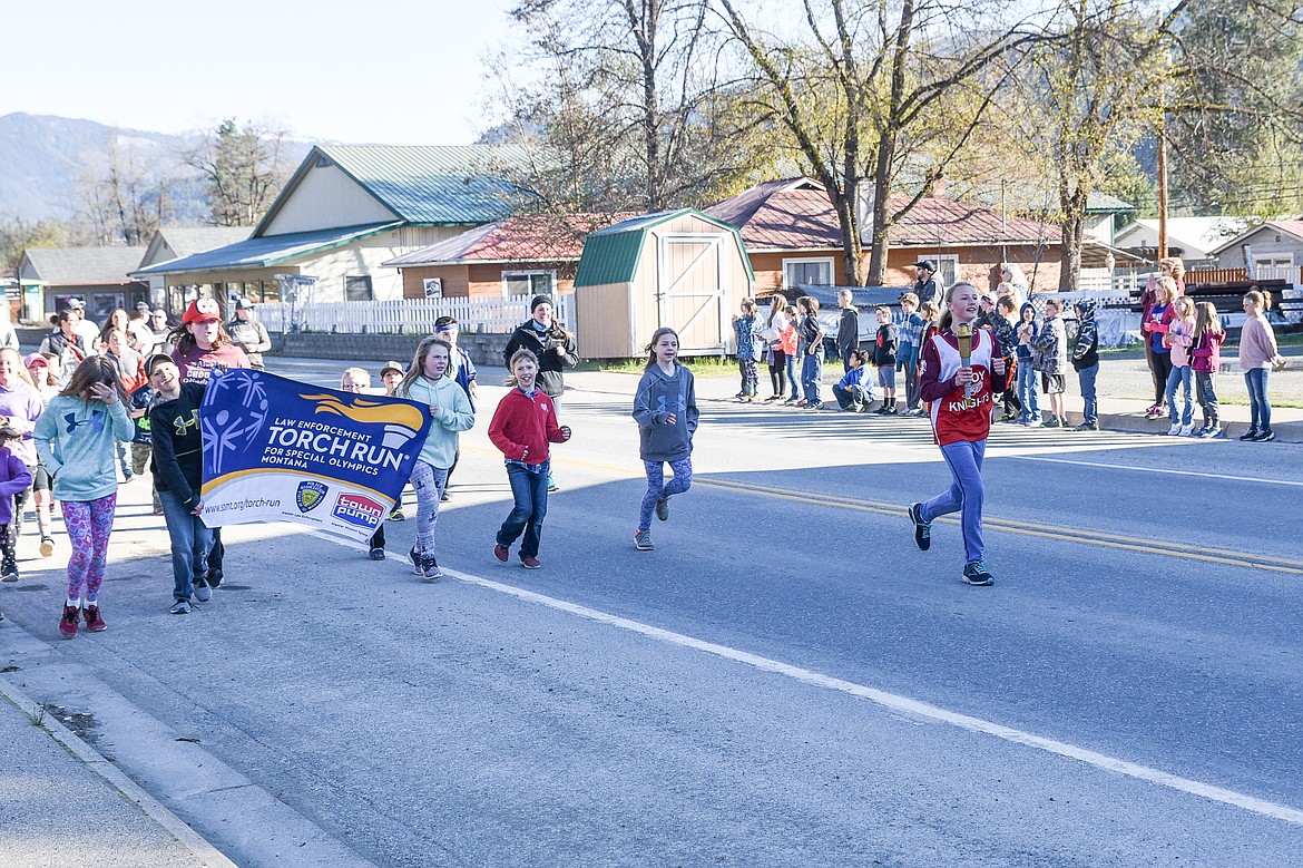 The Special Olympics Torch passes through Troy Monday morning, carried by Autumn Fisher, and accompanied -- and cheered on -- by students from W.F. Morrison Elementary. The annual Law Enforcement Torch Run for Special Olympics was accompanied from the Idaho border east to Happy's Inn. (Ben Kibbey/The Western News)