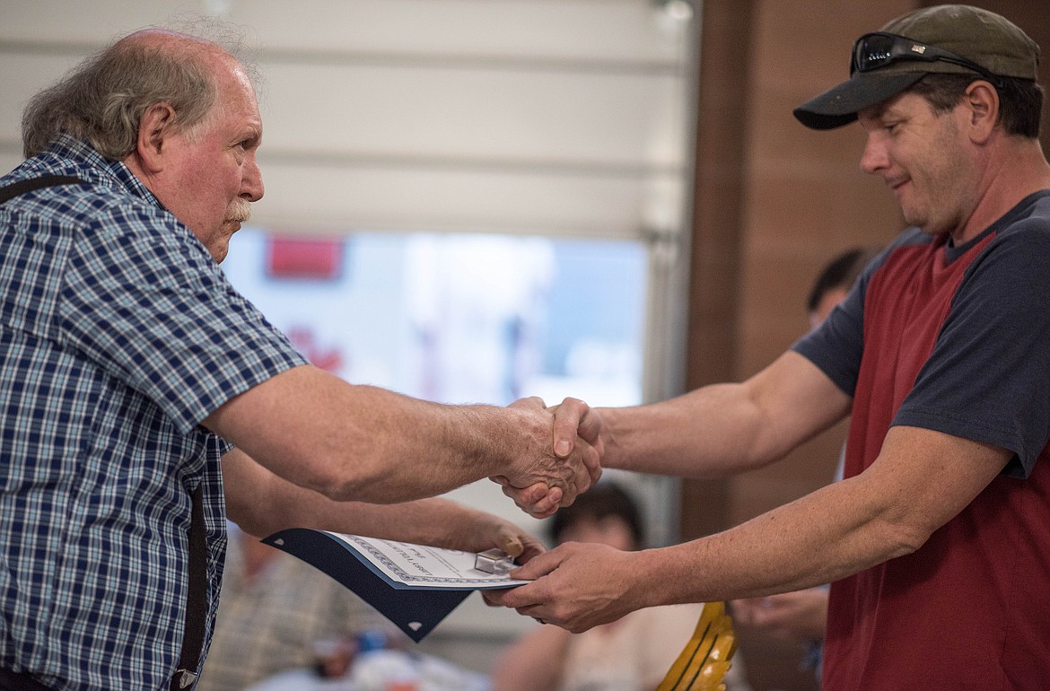 Dick Wernham, left, receives an award handed by Jeff Holder for 28 years of Libby Volunteer Ambulance service, Saturday. (Luke Hollister/The Western News)