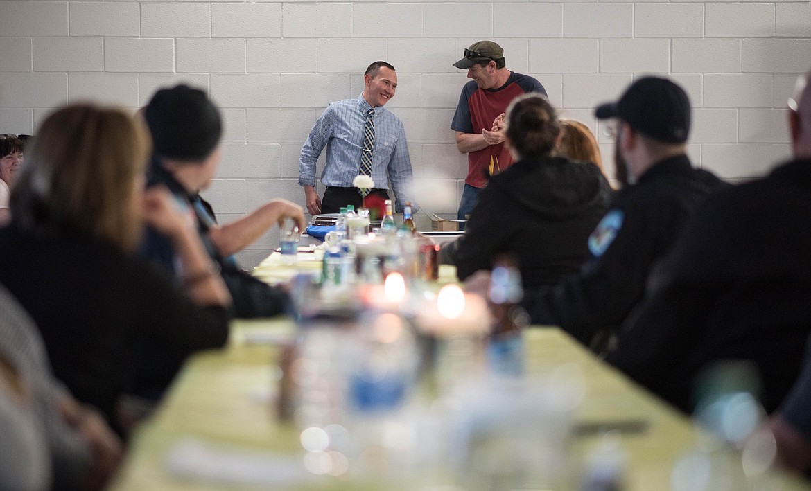 Vincent Brown, left, and Jeff Holder lead the Libby Volunteer Ambulance Annual Awards Banquet, Saturday. Attendees received plaques, pins and hugs for their years of service. (Luke Hollister/The Western News)