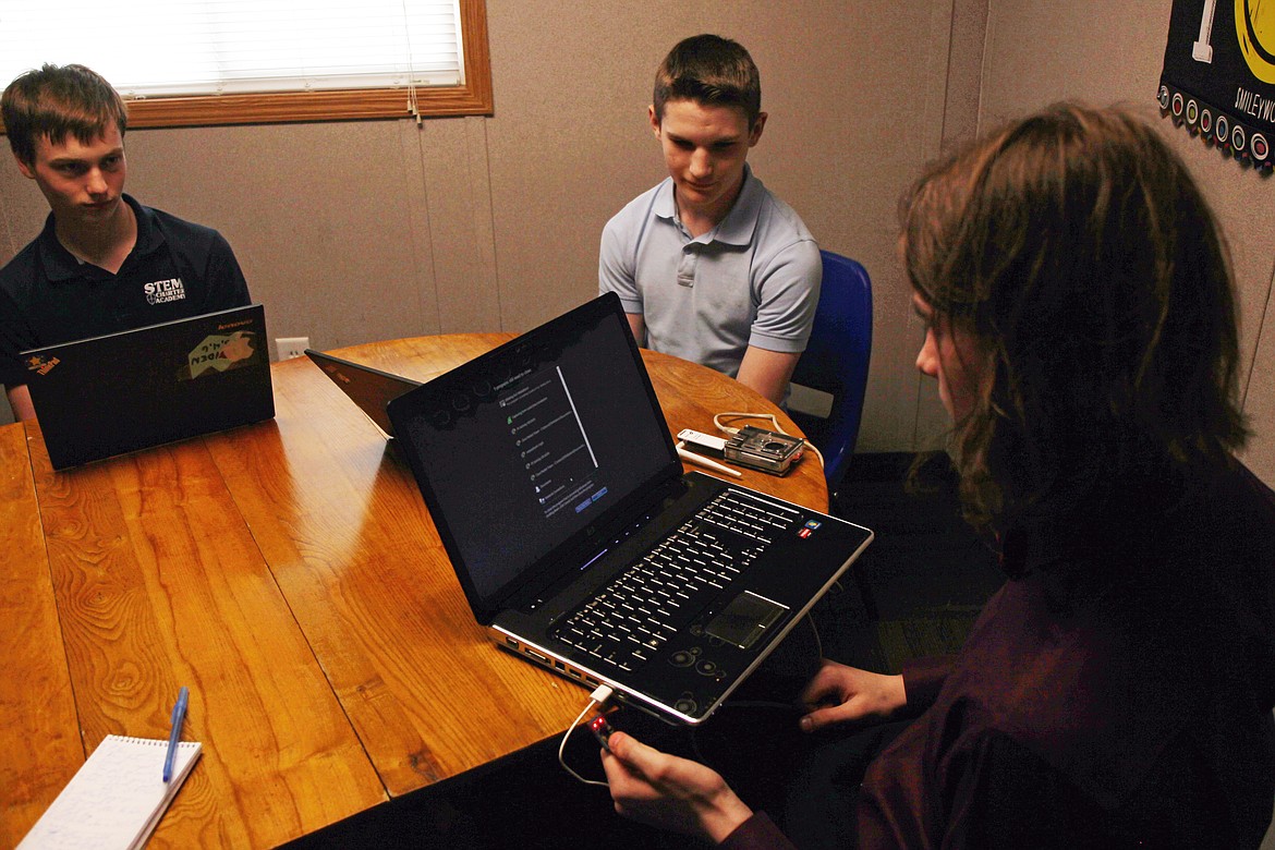 (CRAIG NORTHRUP/Press) Hayden Carroll, left, and Austin Kugler, center, look on as Jordan Higgins demonstrates his technical skills at North Idaho STEM Charter School. Students with computer coding or networking experience will have cybersecurity options in the job market.