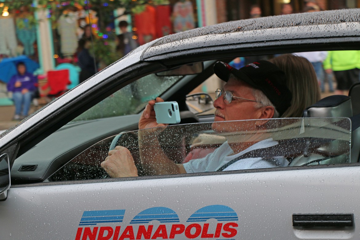 (Photo by CAROLINE LOBSINGER)A driver records the action as he takes part in Friday's Lost in the &#146;50s parade.