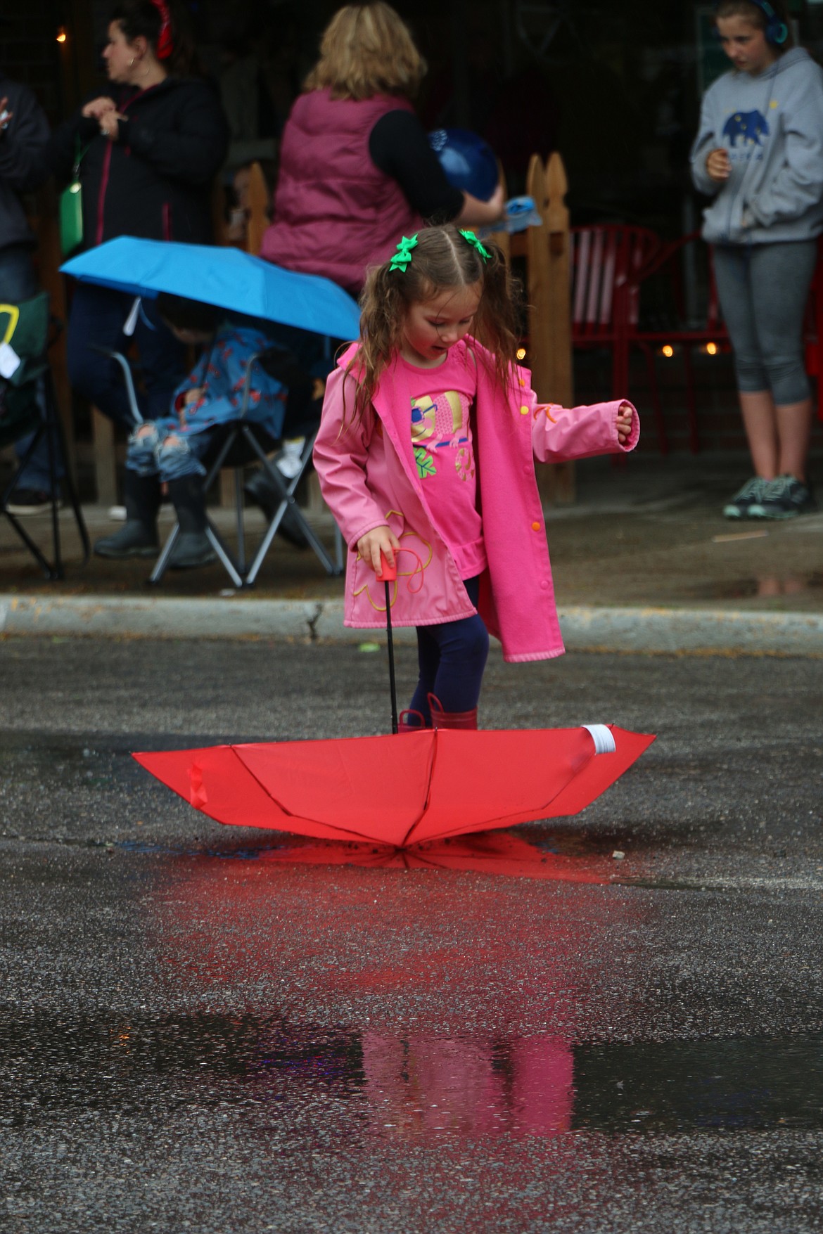 (Photo by CAROLINE LOBSINGER)A youngster has fun playing with her umbrella as she waits for the start of the Lost in the &#146;50s parade on Friday.