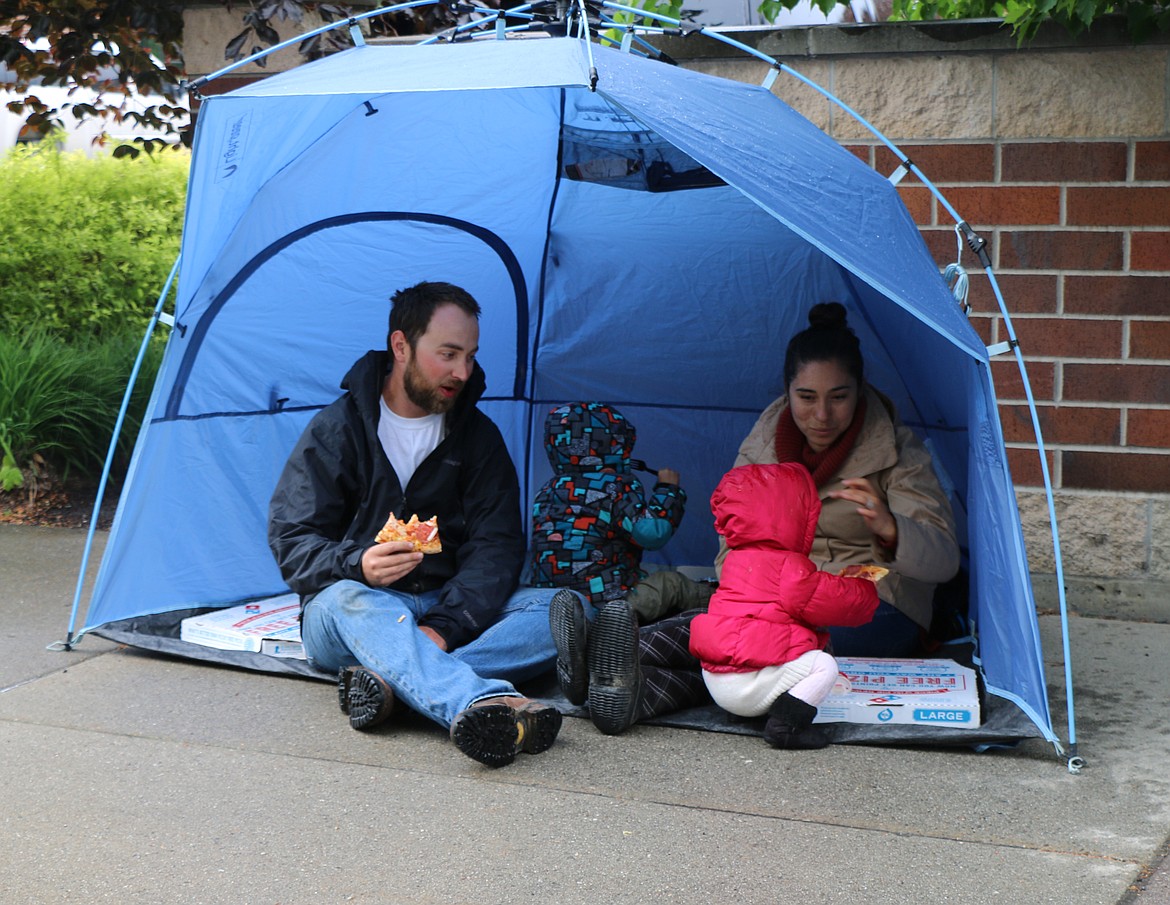 (Photo by CAROLINE LOBSINGER)Kevin, Tessa, Abigail and Cody Chapman enjoy a slice of pie &#151; and stay dry thanks to a tent the family brought &#151; as they wait for the start of Friday's Lost in the &#146;50s parade.