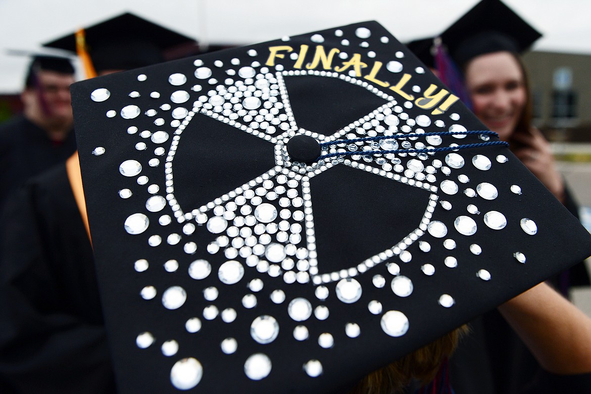 A graduate with a decorative message on her mortarboard files across campus during Flathead Valley Community College&#146;s 51st class commencement ceremony on Friday.