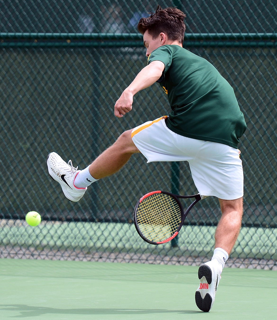 Whitefish's Brendan Buls finishes off a set with a between-the-legs return against Libby's Zack Morrison in the Northwestern A Divisionals at Flathead Valley Community College on Thursday. (Casey Kreider/Daily Inter Lake)