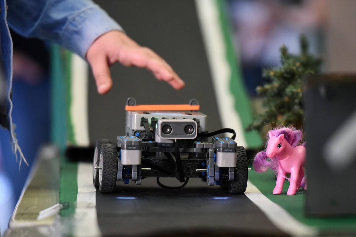 A self-driving automobile prototype navigates through the exhibit of Stillwater Christian School eighth-graders Abby Stillo and Meara Geer.