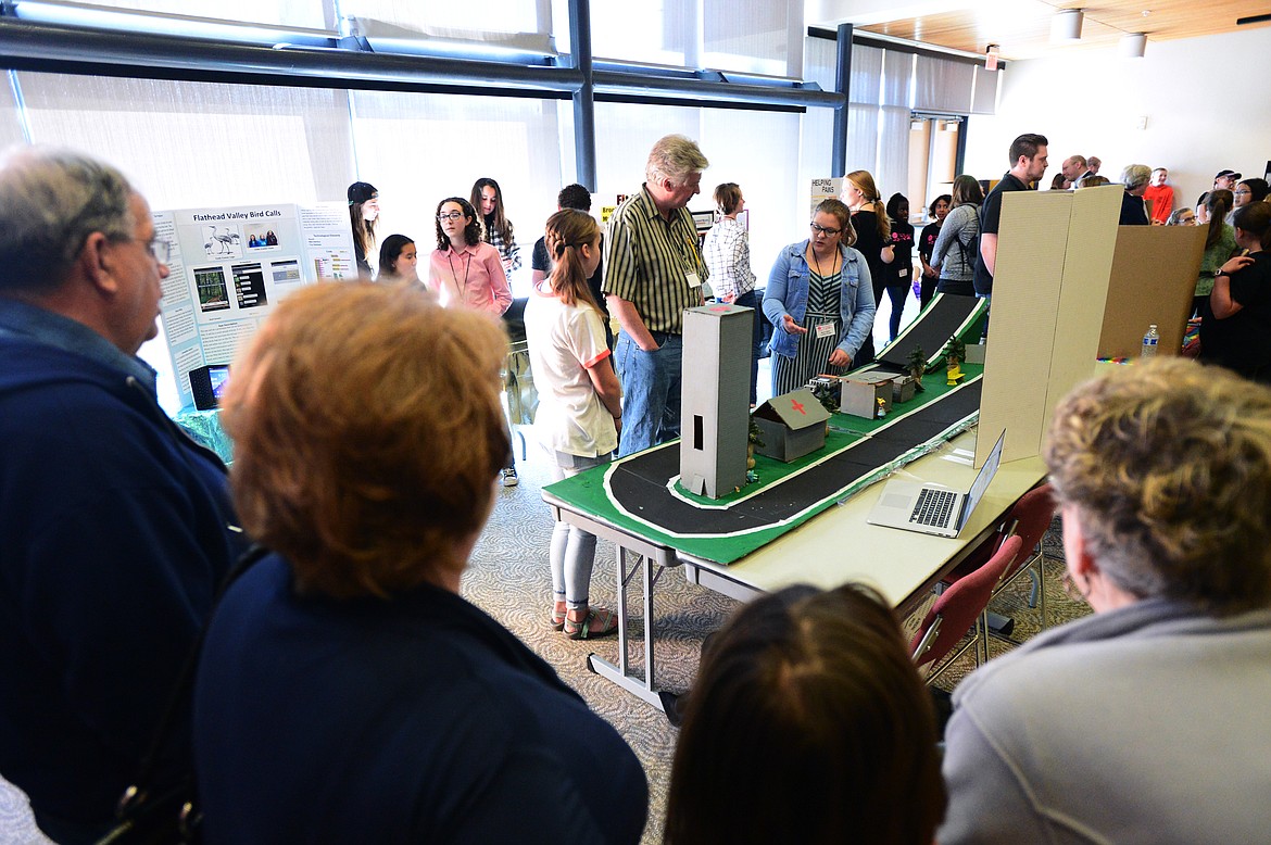 Stillwater Christian School eighth-graders Abby Stills, left, and Meara Geer, in blue jacket, explain their self-driving automobile to a judge at the Code Girls United Northwest Regional App Challenge at Flathead Valley Community College on Saturday, May 11. (Casey Kreider/Daily Inter Lake)