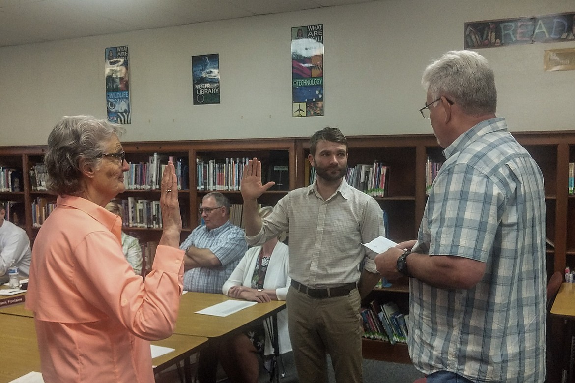 Newly elected Troy Public Schools board trustees Sylvia Maffit and Ben Valentine are sworn in by Troy Mayor Dallas Carr on Monday, May 13. Each will serve a three-year term. (Ben Kibbey/The Western News)