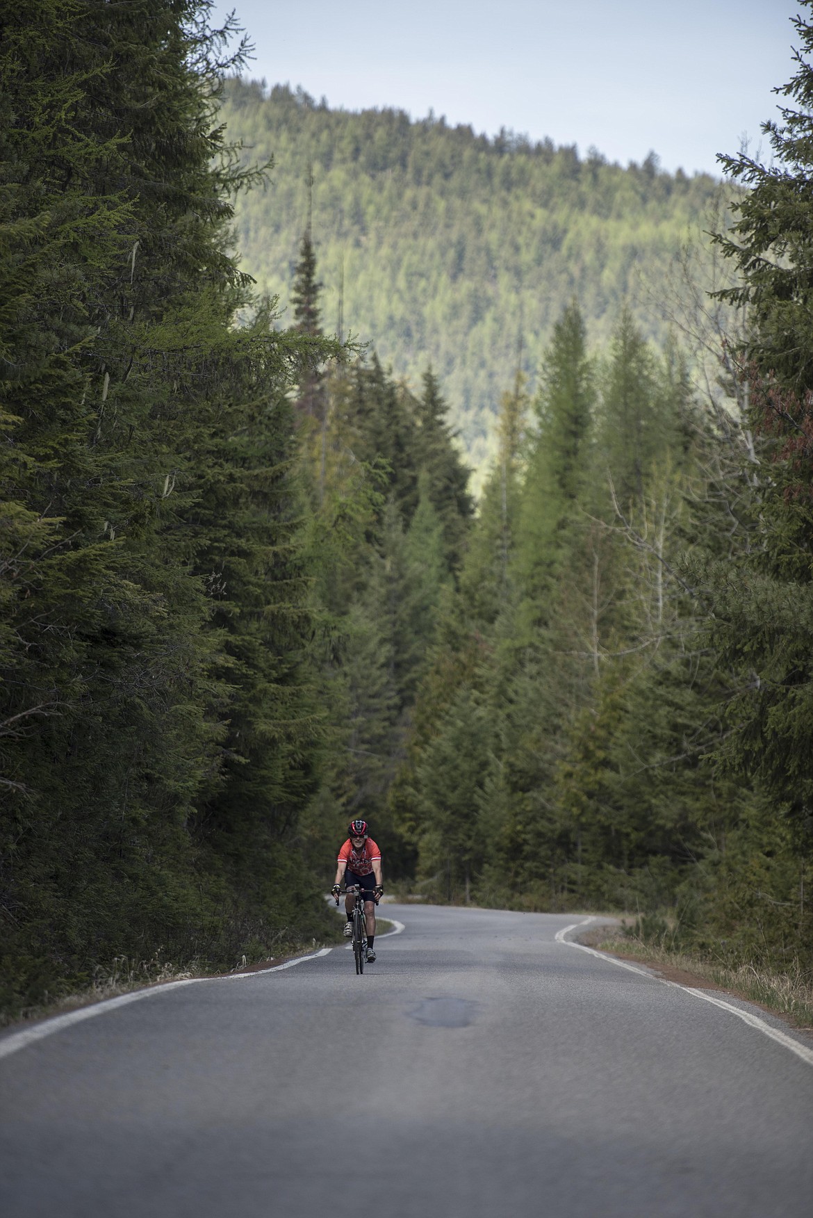 A bicyclist speeds down Pipe Creek Road at the Scenic Tour of the Kootenai River fundraising event, Saturday. (Luke Hollister/The Western News)
