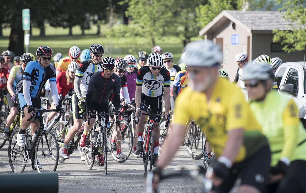 Dozens of bicyclists, escorted by police cars, head to cross the Libby Dam at the Scenic Tour of the Kootenai River fundraising event, Sunday. (Luke Hollister/The Western News)