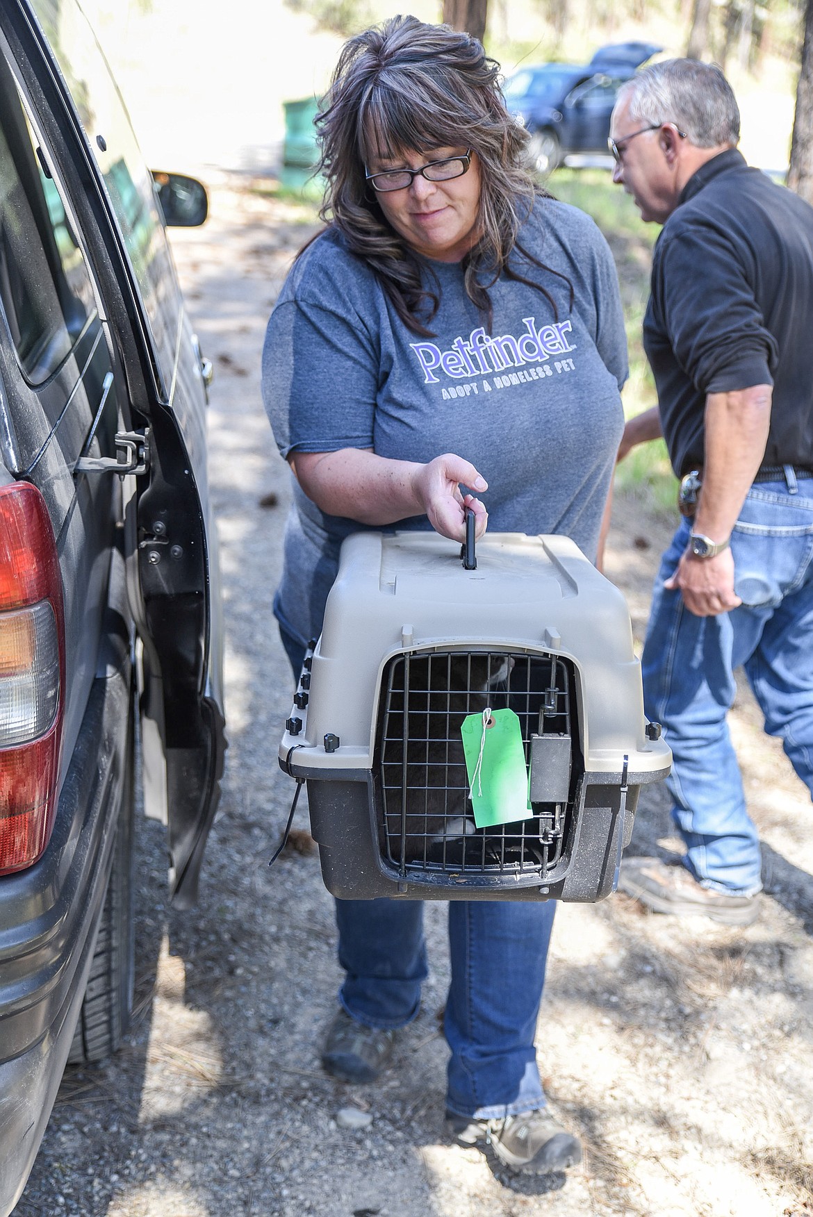 Tobacco Valley Animal Shelter Director Wendy Anderson unloads a carrier holding one of an estimated around 200 cats from a colony in the Yaak Friday, as Lincoln County Animal Control Officer Roger Guches goes to retrieve more cats from the van. (Ben Kibbey/The Western News)