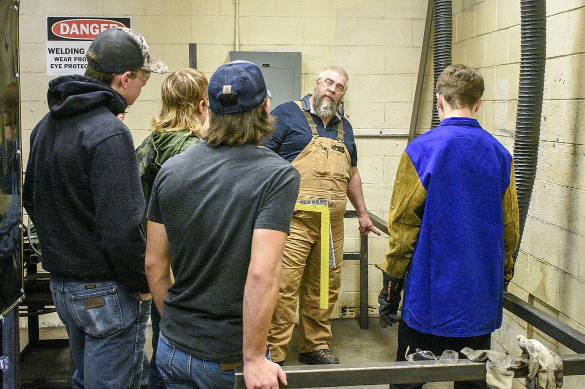 Jeff Thill discusses with his students the angles and measurements on new welding booths they were building in January. (Ben Kibbey/The Western News)