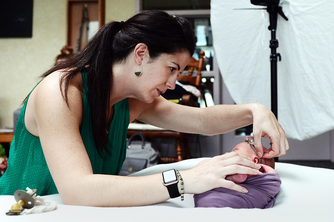 Photographer Dianne Dotter positions a headband on a newborn baby during a session at Kalispell Regional Medical Center on Tuesday, May 7. (Casey Kreider/Daily Inter Lake)