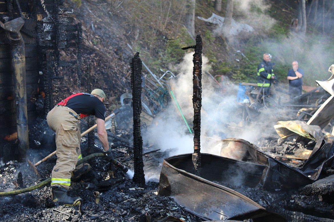 Photo by CHANSE WATSON/ 
SCSO Captain Jeremy Groves sprays water on a hot spot in the rubble of the home on Bank Street late Thursday morning. During the initial part of the investigation, the status of the home&#146;s residents was unknown, but they were located later in the day unharmed.