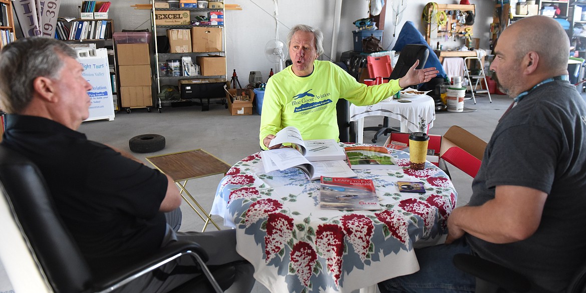 EARNING YOUR pilot's license requires at least 40 hours of flying time and three times that many hours of studying, according to Blue Goose Aviation co-owner Joe Kuberka, center. He goes over the books that are part of the course with Dean McGinnis, left, and Josh Conatser.