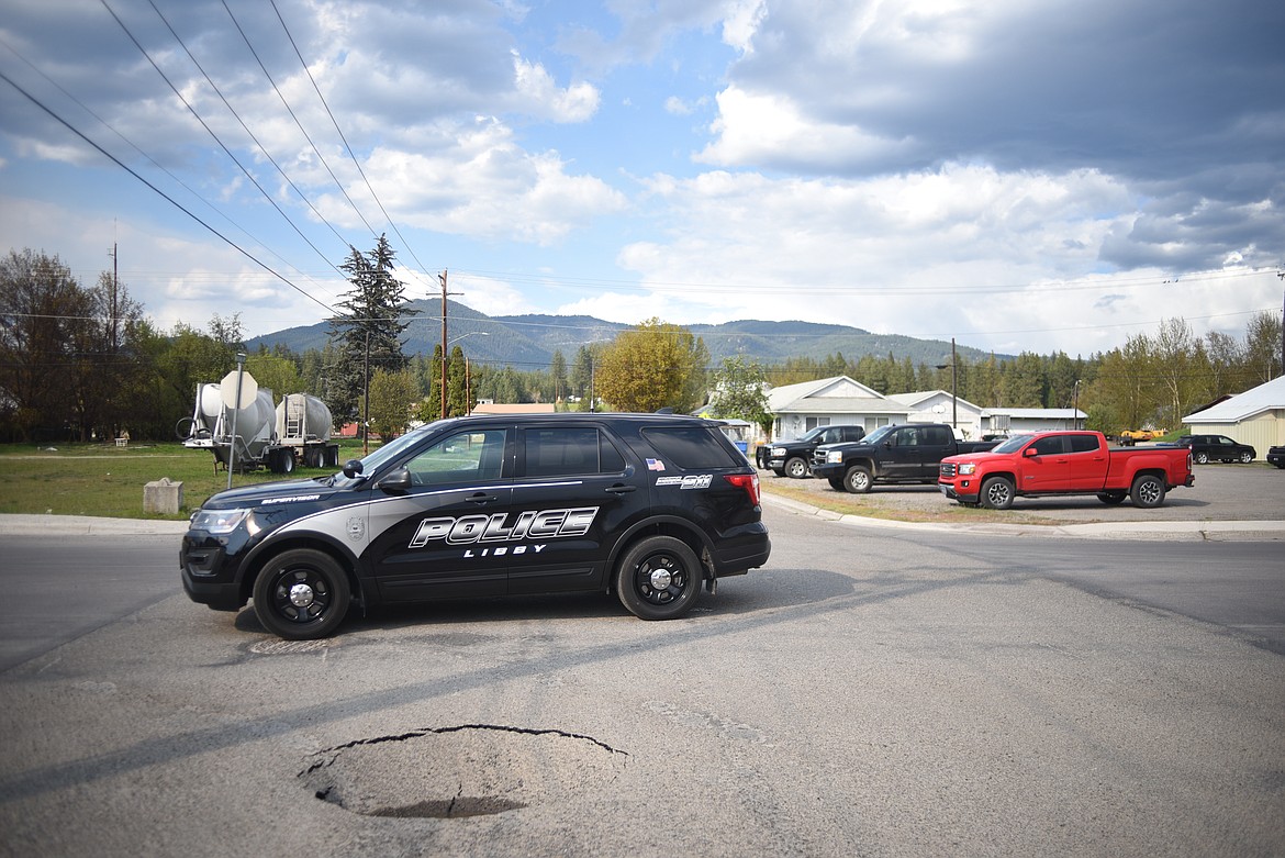 Libby police officers block off part of Montana Avenue due to a sinkhole in an intersection, Tuesday in Libby. (Luke Hollister/The Western News)