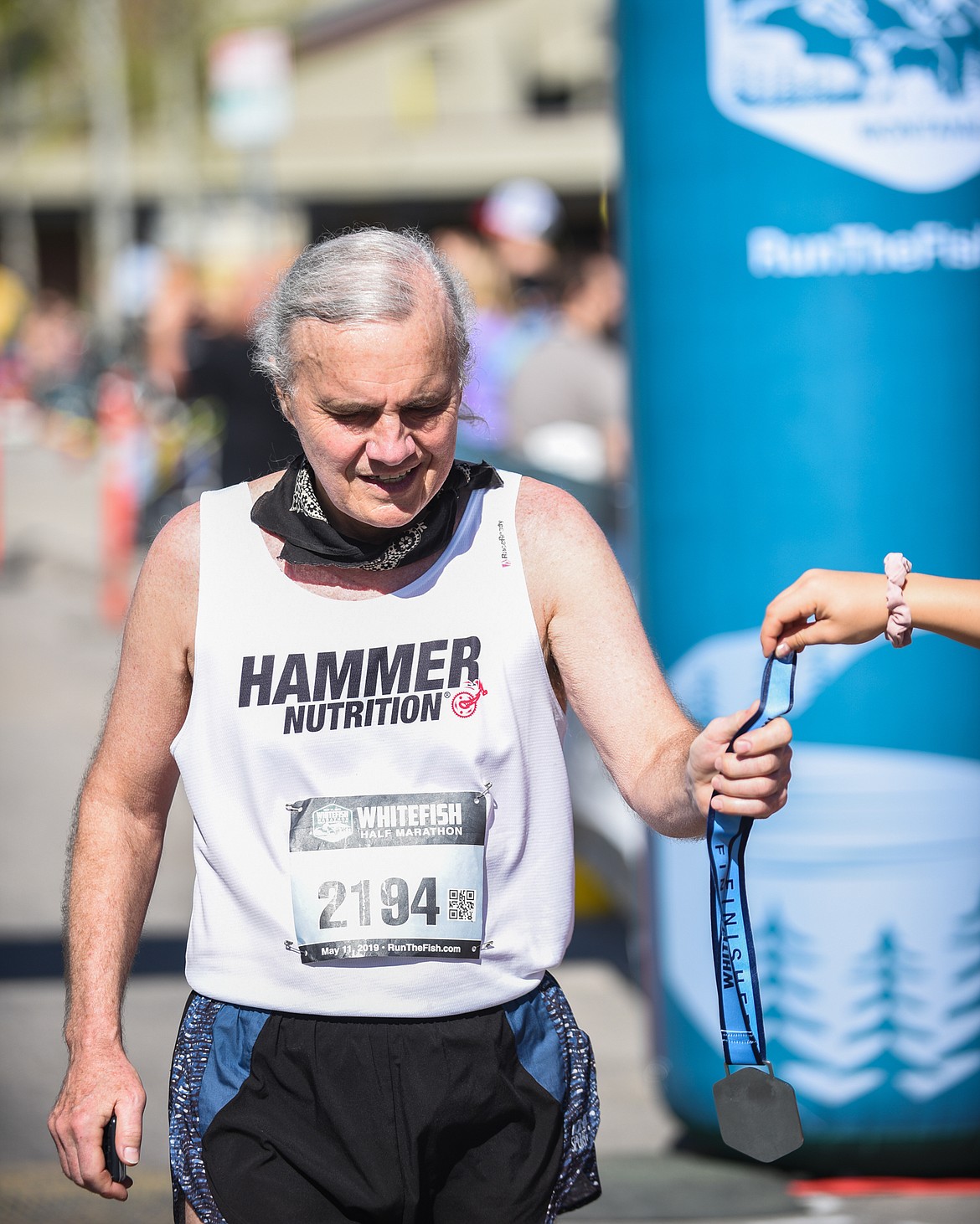 Gil Jordan, 73, accepts his medal after finishing the half marathon on Saturday. (Daniel McKay/Whitefish Pilot)