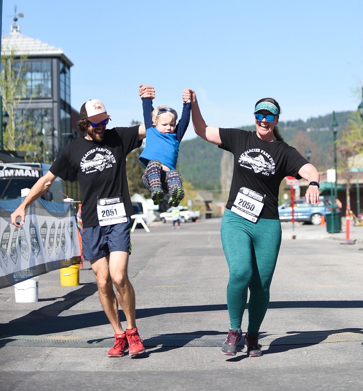 Ed and Courtney Eberhardy hoist up a young runner at the end of the half marathon on Saturday. (Daniel McKay/Whitefish Pilot)