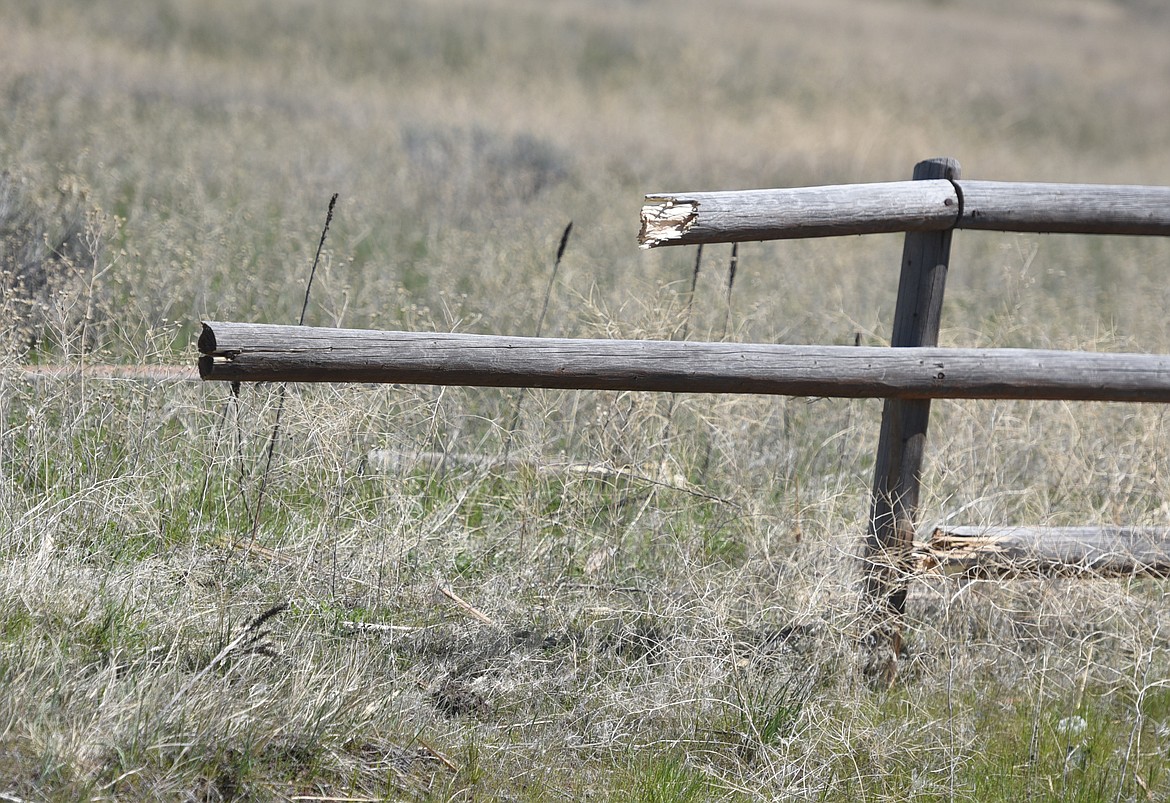 PICTURED IS the broken rail fence that separates an open field and Montana 28 about a half-mile from the junction of U.S. 93 near Elmo. An eastbound sedan crashed through the fence just after 10 a.m. Thursday, May 9.