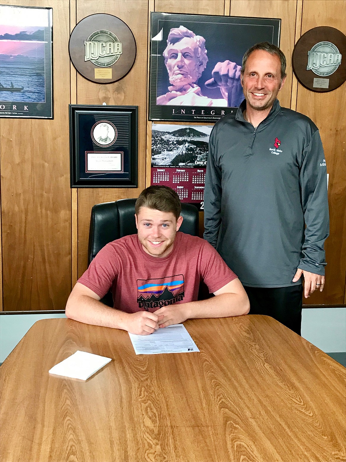 (Photo courtesy of SHANA MOORE)
Sandpoint senior Tyler Moore (left) signs his National Letter of Intent while North Idaho men&#146;s soccer coach Ken Thompson (right) stands by his side.