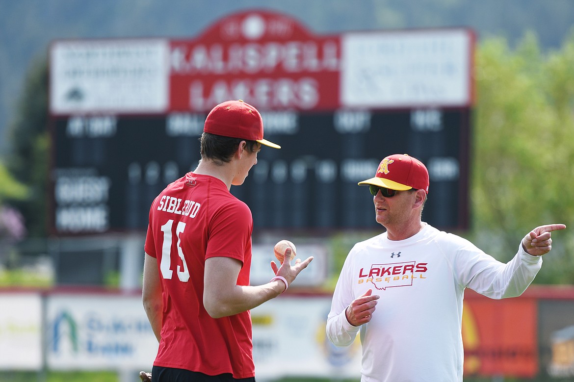 Kalispell Lakers AA head coach Ryan Malmin speaks with Logan Siblerud as players warm up at the start of practice at Griffin Field on Wednesday. (Casey Kreider/Daily Inter Lake)