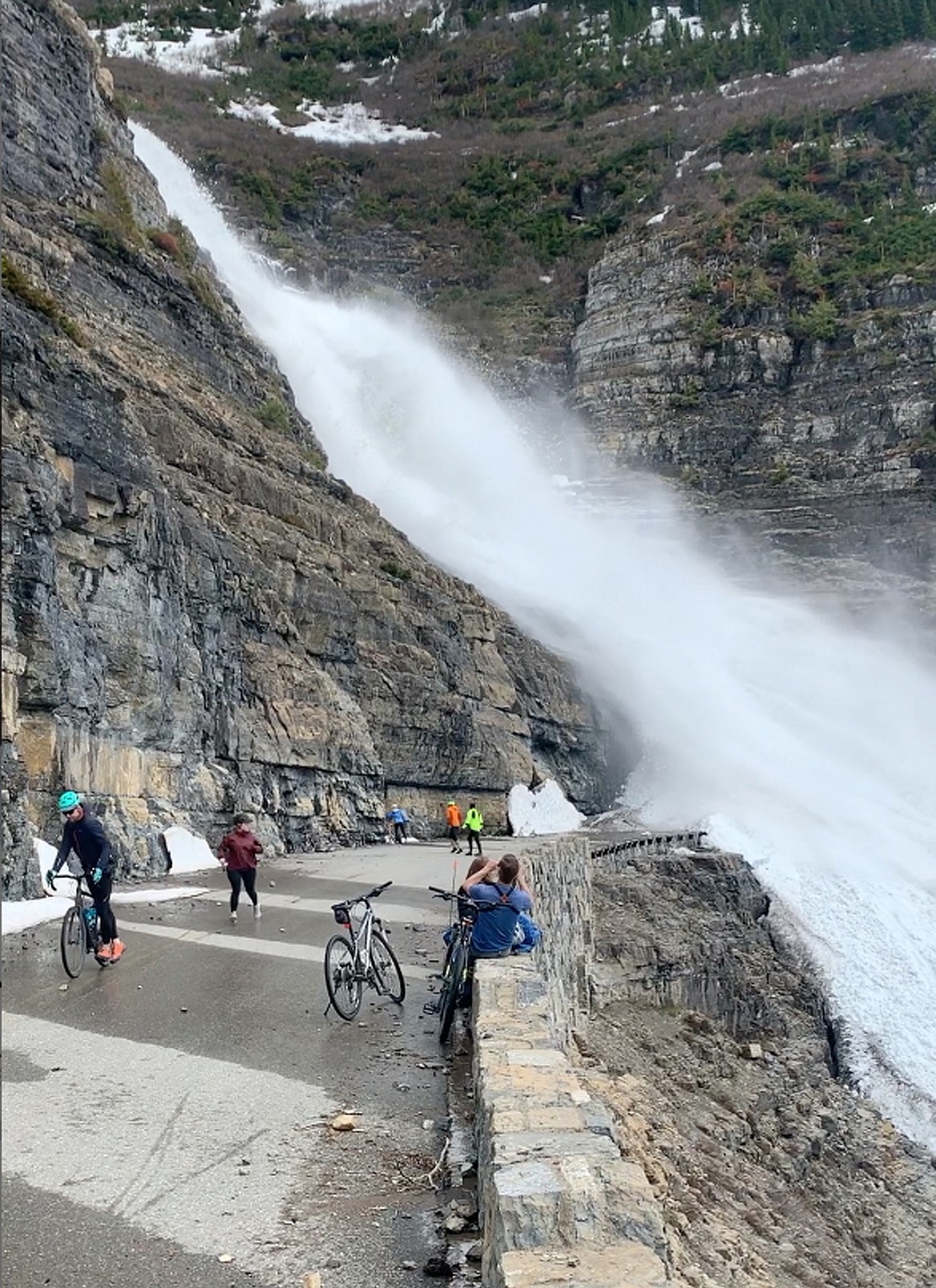 People watch an avalanche cross Going-to-the-Sun Road in Glacier National Park in 2019. The slide stranded 13 cyclists for about eight hours. (Photo provided/GNP)