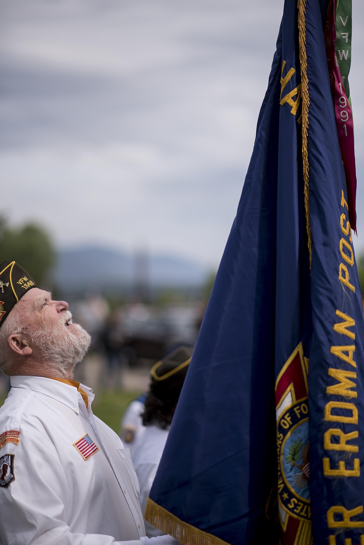 Libby Veterans of Foreign Wars Quartermaster Paul Mammano straightens out his flag during a Memorial Day service, Monday at the Libby Cemetery. (Luke Hollister/The Western News)