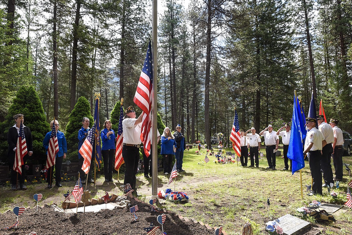 Troy VFW Post 1548 member Maria Gregory raises and lowers the American flag during the Memorial Day service at Milnor Lake Cemetery. (Ben Kibbey/The Western News)