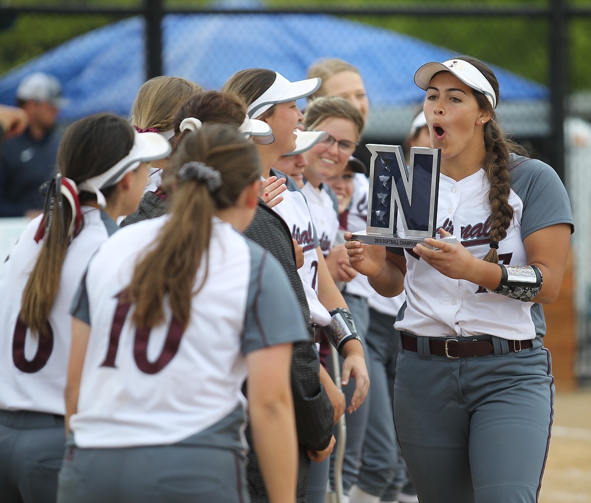 North Idaho College pitcher Madi Mott shows the championship trophy to her teammates after the Cardinals won the Northwest Athletic Conference softball tournament Monday, beating Edmonds 9-1.