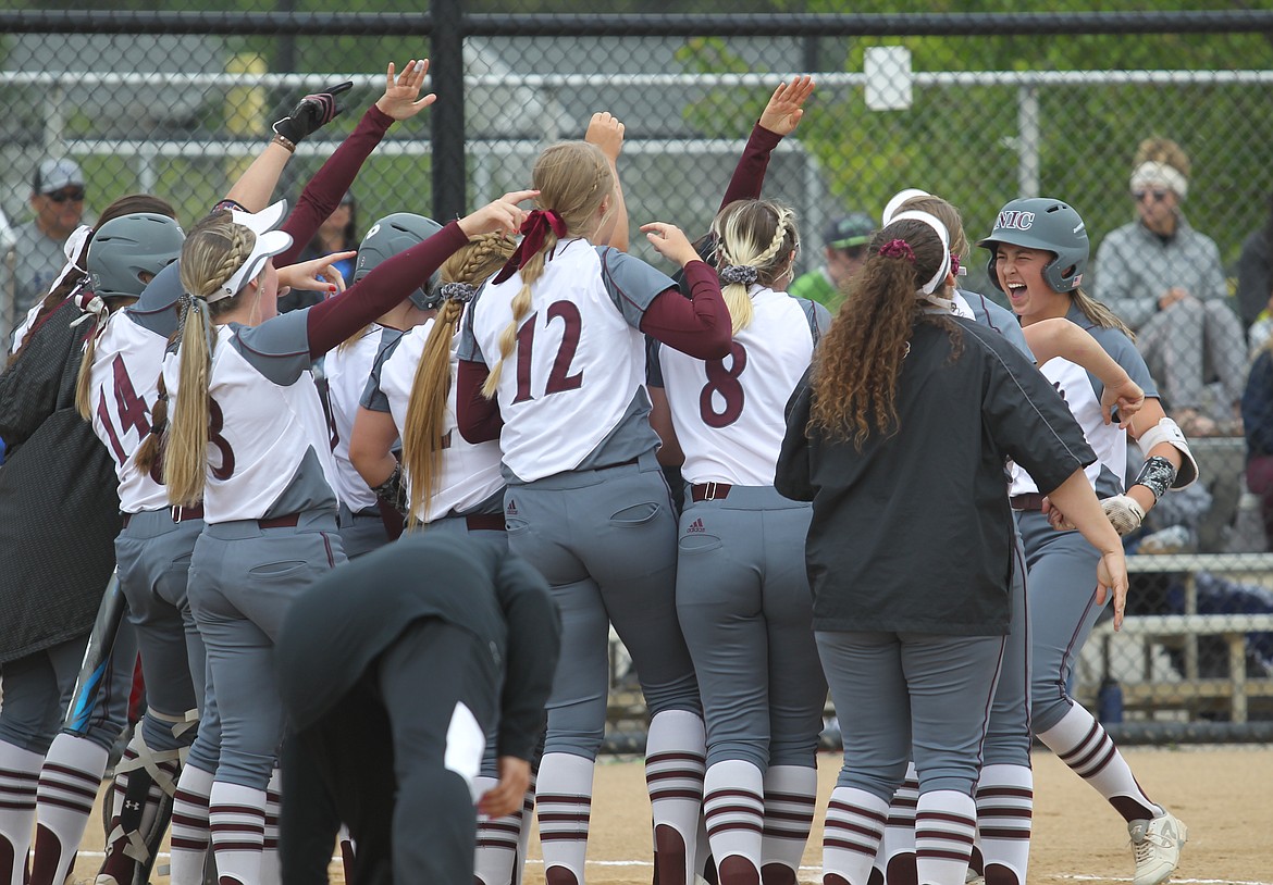 MARK NELKE/Press
Sarah Williams, right, is welcomed home by her North Idaho College teammates after hitting a second-inning home run against Edmonds on Monday in the championship game of the Northwest Athletic Conference softball tournament at the Dwight Merkel Sports Complex in Spokane.