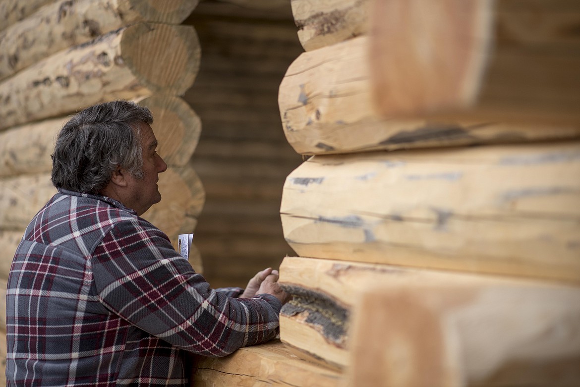 Marvin Hobson, who drove down from Olympia, looks inside of a log home for sale during the annual amish Eagle Valley Community Auction, May 18. (Luke Hollister/The Western News)