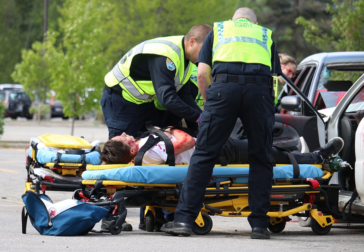 (Photo by MARY MALONE)
Sandpoint High School senior Curtis Hauck is strapped into a stretcher by emergency crews during the mock DUI scenario, &quot;Operation Grad Night,&quot; Tuesday at Sandpoint High School.