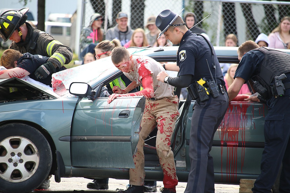 (Photo by MARY MALONE)
Lake Pend Oreille High School senior Mason Deal is helped from a car crash during the mock DUI scenario, &#147;Operation Grad Night,&#148; Tuesday at Sandpoint High School.