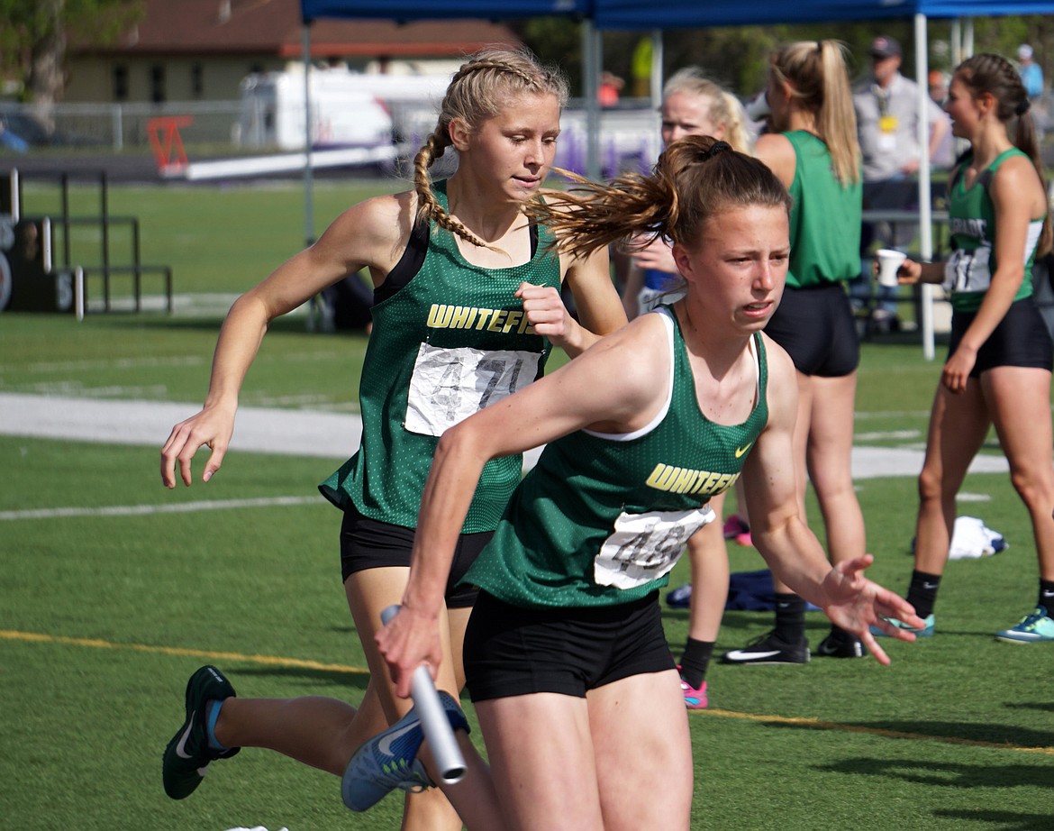 Bulldog Tommye Kelly hands off to Mikenna Ells for the anchor leg of the 4x400 relay at the state meet in Laurel. (Photo courtesy Matt Weller)