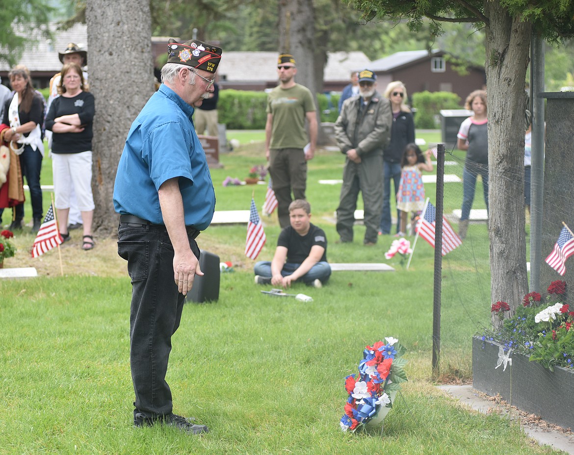 Dennis Dryer, with the Lion Mountain VFW Post 276, prepares to salute a wreath after placing it during the Memorial Day Ceremony Monday at the Whitefish Cemetery. (Heidi Desch/Whitefish Pilot)