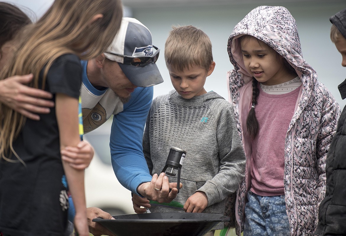 Yosi Vick, middle, and Zon Johnson, right, learn how to pan for gold, Wednesday at the McCormick School Rendezvous. (Luke Hollister/The Western News)