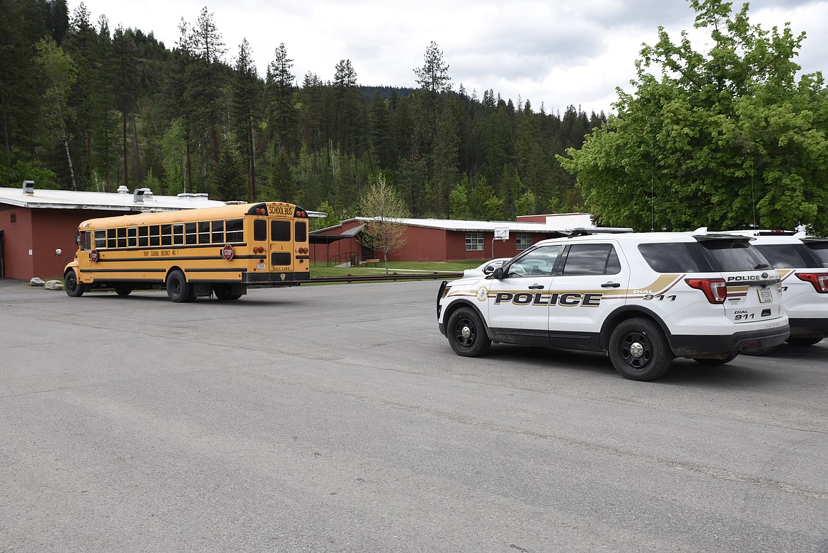 Troy City Police cars sit outside Troy High School and a bus is parked to restrict traffic through the parking lot Tuesday. Troy schools were on lock down and bus routes and after school activities were canceled after a chase that turned into a foot pursuit. (Ben Kibbey/The Western News)