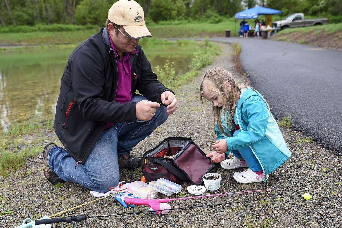Glenn Johnson and Felicity Johnson get their bate ready at the Lil&#146; Anglers Fishing Day at the Mill Pond on Saturday. Glenn said that Felicity seemed more interested in playing with and &#147;kissing&#148; the worms at first. (Ben Kibbey/The Western News)