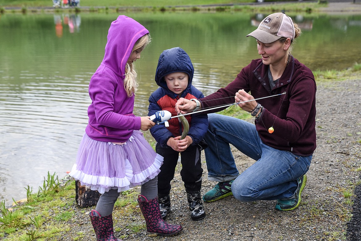 Gabby Deitrick gets an assist from John and Hannah Deitrick with her catch, at the Lil&#146; Anglers Fishing Day at the Mill Pond on Saturday. Both John and Gabby were on their second catch of the day. (Ben Kibbey/The Western News)