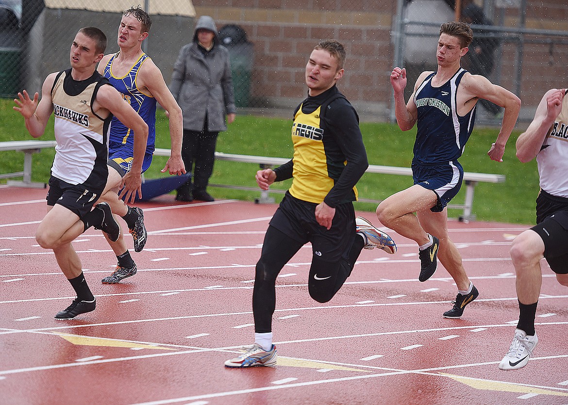IAN FARRIS, in the yellow shirt, runs the 200-meter dash finals at the Western C Divisional meet in Missoula. He placed third with a time of 23.95. (Joe Sova/Mineral Independent)