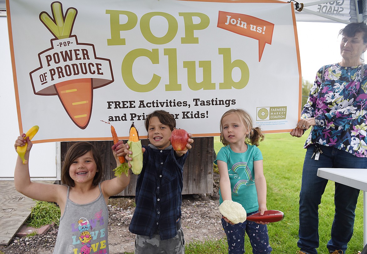 POP STANDS for Power of Produce, and that was the emphasis during the first Ronan Farmers Market of the 2019 season last Thursday, May 16. The market period of 4 to 7 p.m. gave youngsters an opportunity to win &#147;tokens&#148; they could use at vendors at the market on the grass behind the Ronan Visitors Center. According to market organizer Brianna Ewert, the Lake County Community Development Corporation received a federal grant to make the POP program possible. Pictured above are Hadassah and Noah Ison, and Elise Cantlon. Holding the banner is Mary Ann Ewert. (Joe Sova photos/Lake County Leader)