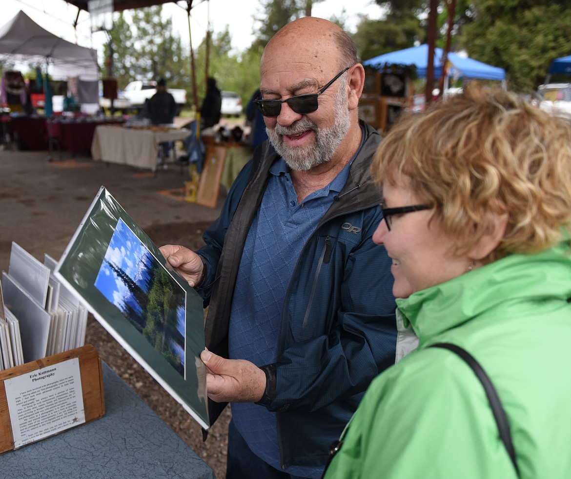 RICH AND Teresa Keenan, who live in Delhi, Iowa, and relatives from Missoula visited the Cherry Blossom Festival last Saturday at the Yellow Bay Community Clubhouse. They bought this print by Eric Kottman.