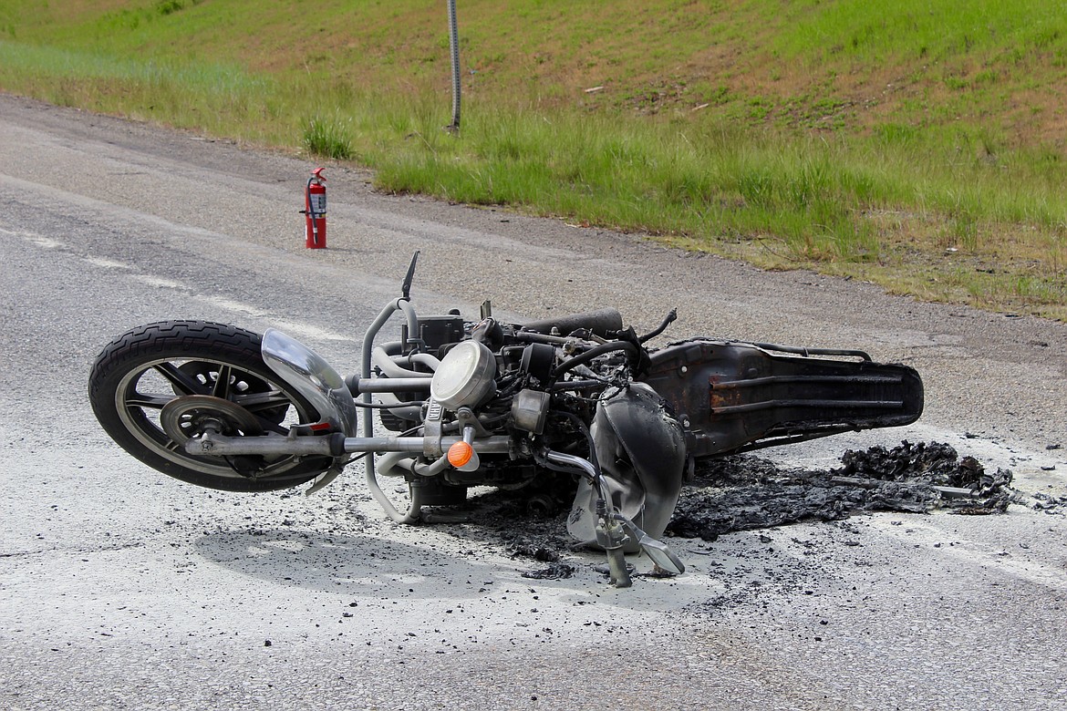 One of the wrecked motorcycles lays on the interstate. This bike caught fire and had to be put out.