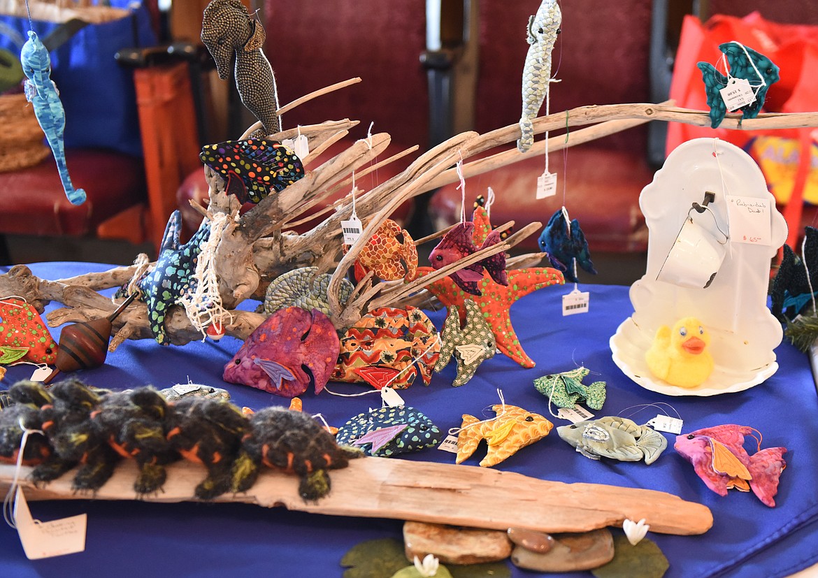 COLORFUL ITEMS were on display at the Yesteryear Relics booth during the Yellow Bay Cherry Blossom Festival last Saturday. Below left is a reproduction of Flathead Lake among the items in the silent auction. (Joe Sova photos/Lake County Leader)